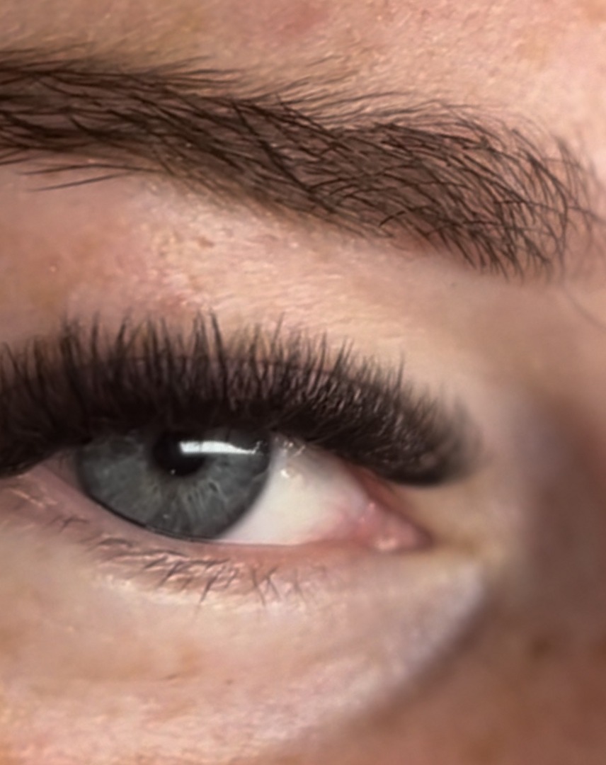 Wimperset en wenkbrauw bij een grijsblauw oog